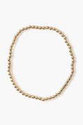 Alexa Leigh gold beaded necklace arranged in a loose circle, echoing the look of a stacking or gold ball bracelet, crafted with 14k gold plated elegance.