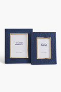 Two blue textured photo frames by Two's Company—a large and a small—are displayed side by side. Each features an ostrich pattern vegan leather finish and comes with branded placeholder paper.