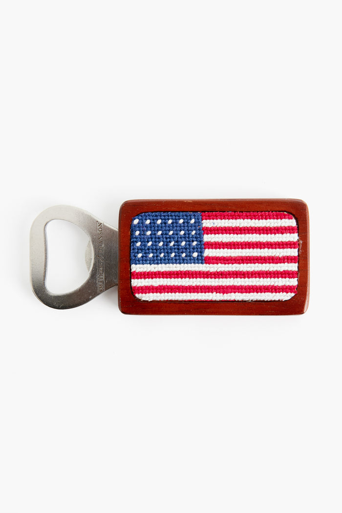 Smathers and Branson’s hand-stitched bottle opener features a rectangular wooden handle and a detailed needlepoint American flag design.