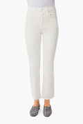 A person wearing off-white high-rise jeans from MOTHER, a white top, and patterned slip-on shoes.