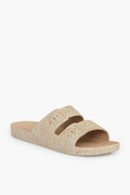 The Freedom Moses beige sandal features two wide straps with a textured, woven pattern on both the straps and sole. This stylish vegan sandal offers a sustainable footwear choice for eco-conscious shoppers.