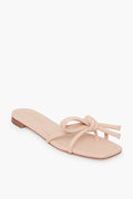 The Loeffler Randall Ballet Hadley Sandal in beige features a square toe, thin knotted bow detail straps, and a low heel, crafted from Italian glove calf leather.