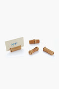 Four Chefanie wine corks rest on a white surface, one holding a card labeled Olympia. These distinctive table accessories bring a hint of Palm Beach decor to your dining table.