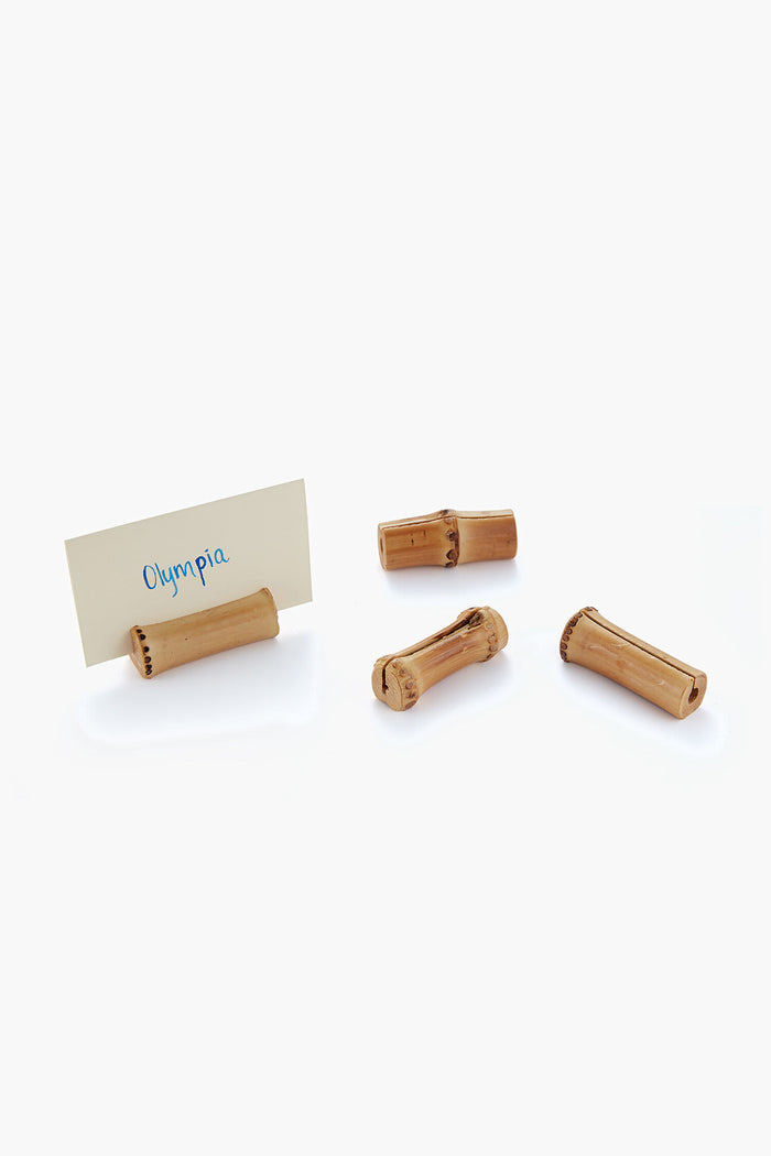 Four Chefanie wine corks rest on a white surface, one holding a card labeled Olympia. These distinctive table accessories bring a hint of Palm Beach decor to your dining table.