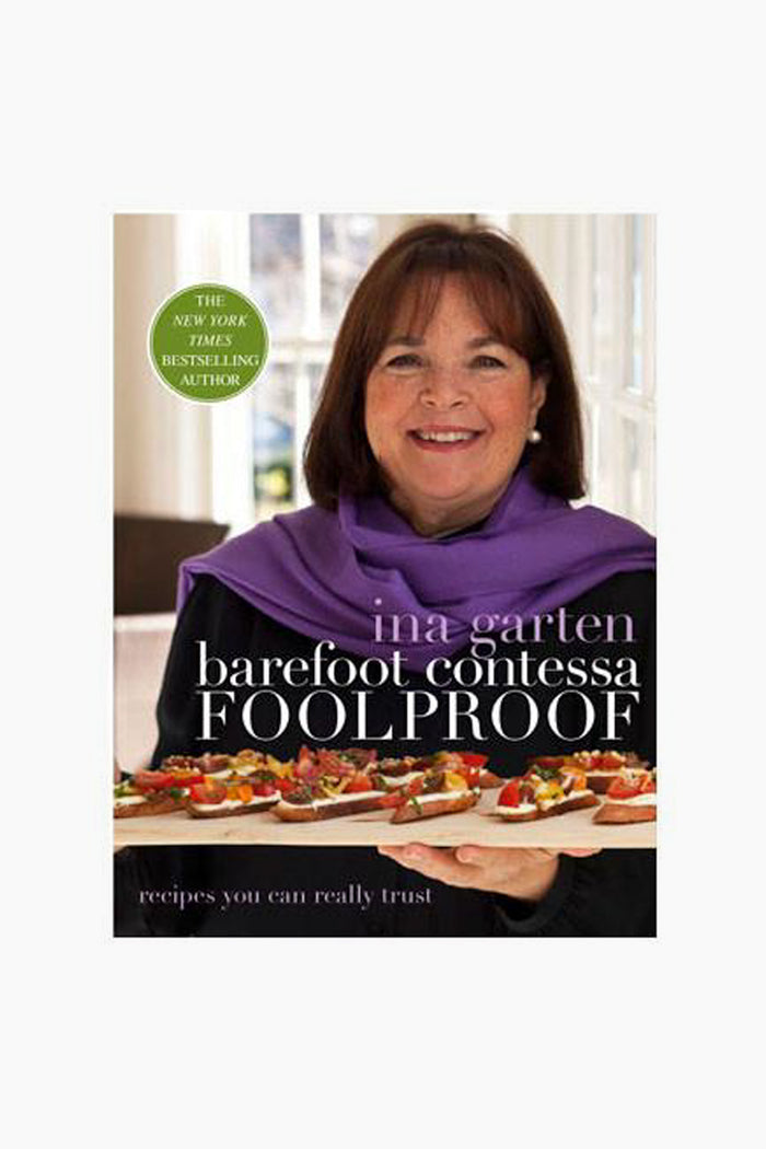 Cover of the Rizzoli cookbook Barefoot Contessa Foolproof by Ina Garten, showing her smiling and holding a tray of appetizers—ideal for make-ahead recipes and menu planning.