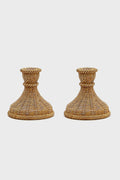 A pair of woven rattan candle holders by Two's Company, featuring wide bases and flared tops—ideal for bringing coastal charm to your home decor.