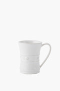 A white Juliska mug crafted from ceramic stoneware features a flared rim, decorative rope-like bands, and small floral accents.