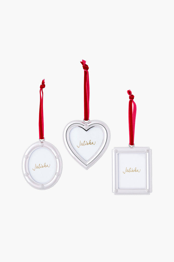 Three Juliska silver picture-frame ornaments—round, heart-shaped, and square—hang from red ribbons, ideal for festive holiday décor or as a thoughtful hostess gift.
