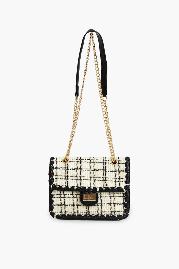 The Urban Expressions rectangular tweed purse features a black and white checkered pattern, gold chain strap, black leather trim, and gold clasp closure. This chic crossbody bag blends classic style with modern elegance.