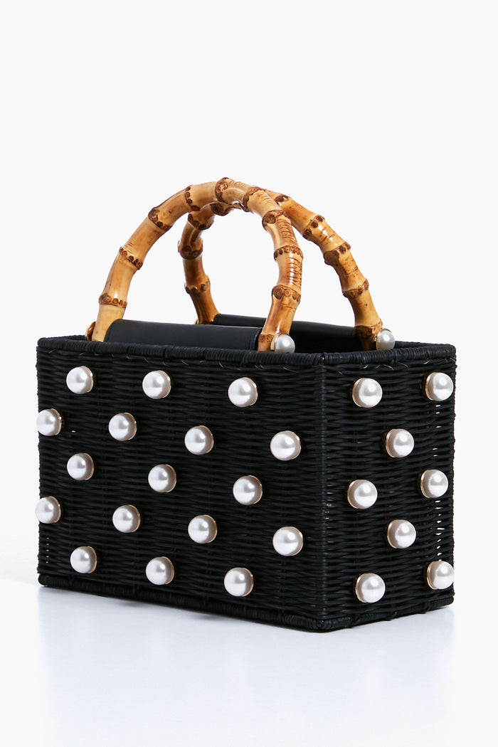 BTB rectangular bag with a black bamboo handle, woven rattan body, and large pearl-like studs decorating all sides.