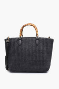 Moda Luxe black woven bamboo handle handbag with a detachable shoulder strap, featuring chic bamboo-style handles and a vegan straw tote design.