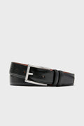 A black leather belt from Trafalgar, featuring a silver metal buckle, is coiled to showcase men's luxury accessories made from full grain leather.