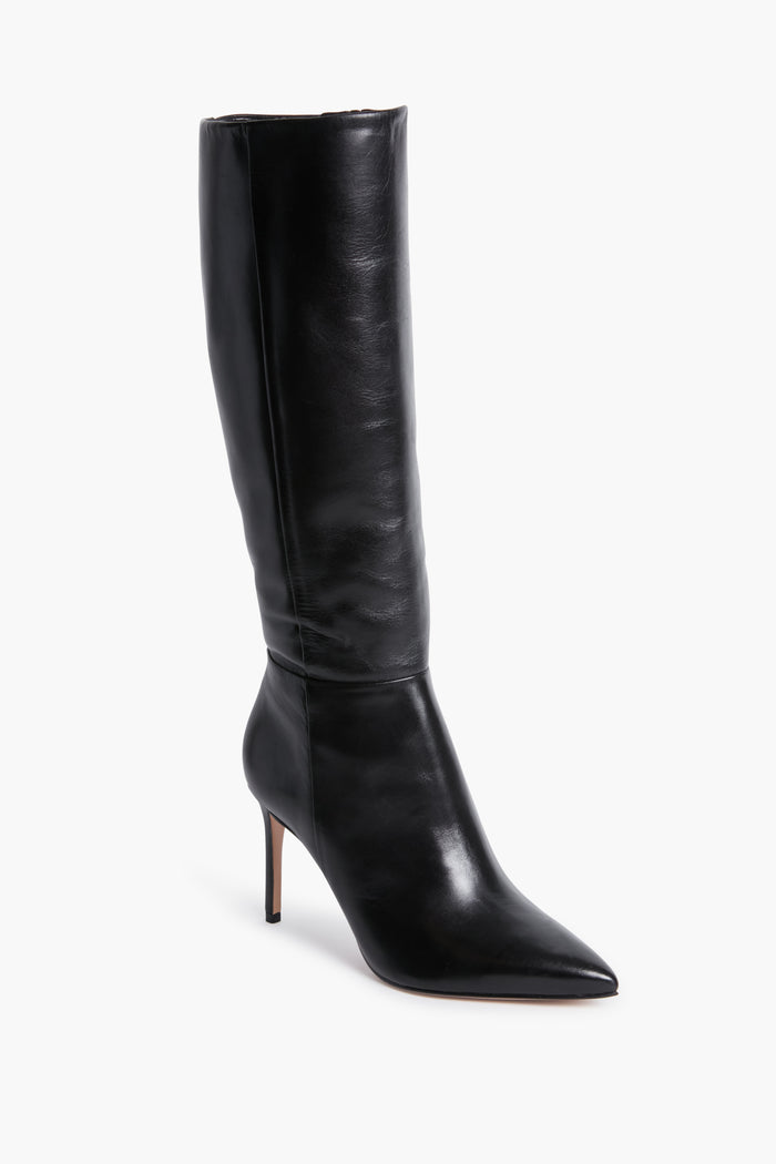 A single black leather knee-high boot by Schutz is shown, featuring a pointed toe and a high stiletto heel.