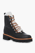 Marc Fisher black leather lace-up winter boots featuring a thick lug sole, metal eyelets, brown laces, and white shearling lining on the tongue and collar.