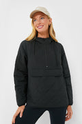 A woman stands and smiles, wearing a beige baseball cap and the Black Bennett Pullover by Pomander Place.