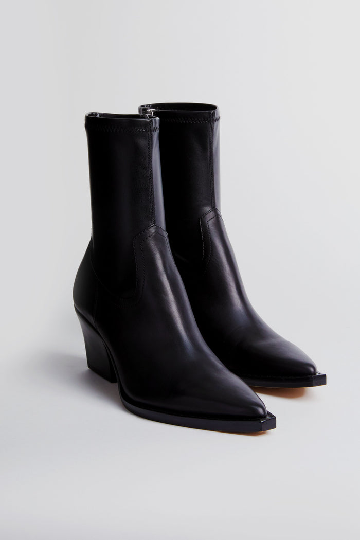 A pair of black Dolce Vita Rutger booties featuring a pointed toe and chunky heel, crafted from premium leather.