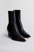 A pair of black Dolce Vita Rutger booties featuring a pointed toe and chunky heel, crafted from premium leather.