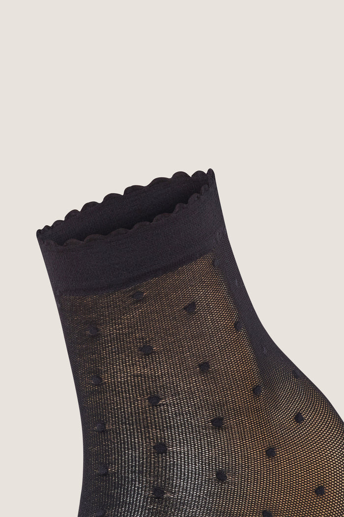 Black Sheer Polka Dot Socks with a classic scalloped cuff, featuring a fun and effortless polka dot pattern, embodying a high-end, stylish design for versatile wear.