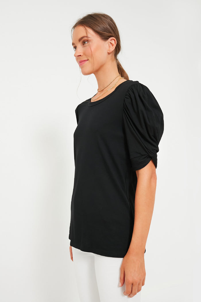 Model wearing the Black Vesty Puff Short Sleeve Crewneck with classic puffed sleeves and knot tie details, paired with white bottoms for an effortless, fun, high-end look.