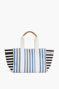 A Rue de Verneuil tote bag featuring vertical blue and white stripes in the center, horizontal black and white stripes on the sides, two white handles, and a small brown grip.