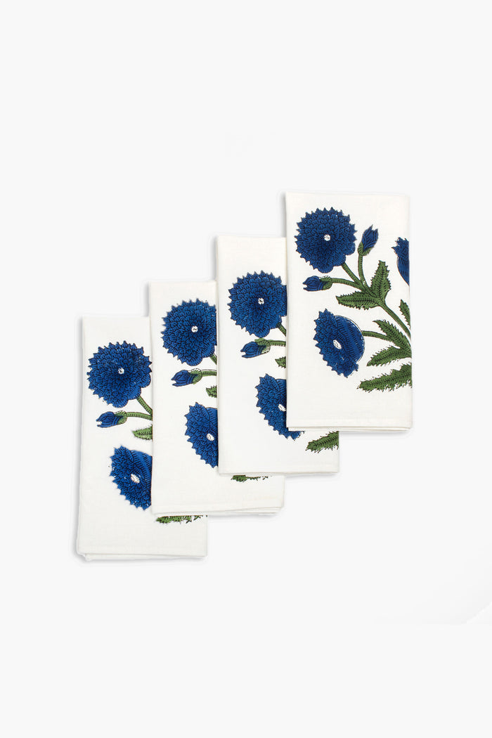 Four white Chefanie napkins, featuring a blue and green floral pattern, are neatly stacked. These block-printed cotton napkins add a refreshing touch to any table setting.