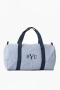 A blue and white striped overnight bag by Caton's Wharf, featuring navy handles and "BYE" embroidered on the front.