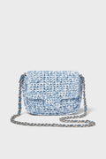 A small Italian crossbody bag by Caterina Bertini in blue and white, featuring a woven design, flap closure, and chain strap.