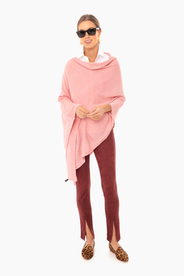 A woman in a Pomander Place pink layering poncho, white shirt, burgundy pants with front slits, leopard print loafers, sunglasses, and gold earrings—an ideal look for al fresco dining.