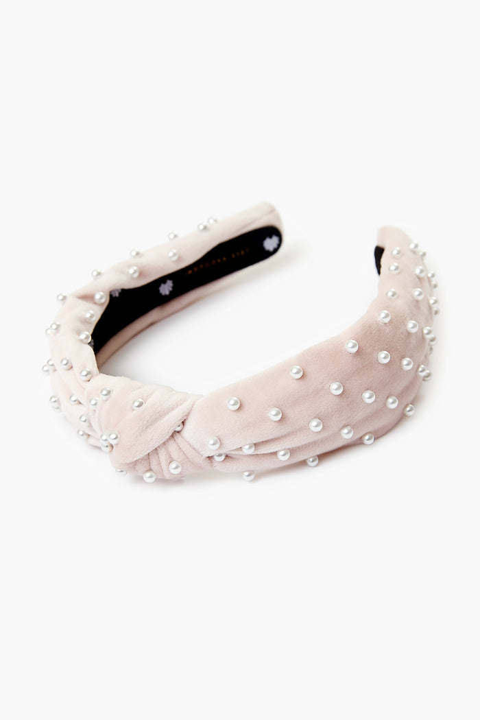 Lele Sadoughi light pink velvet headband embellished with evenly spaced white faux pearls for an elegant look.