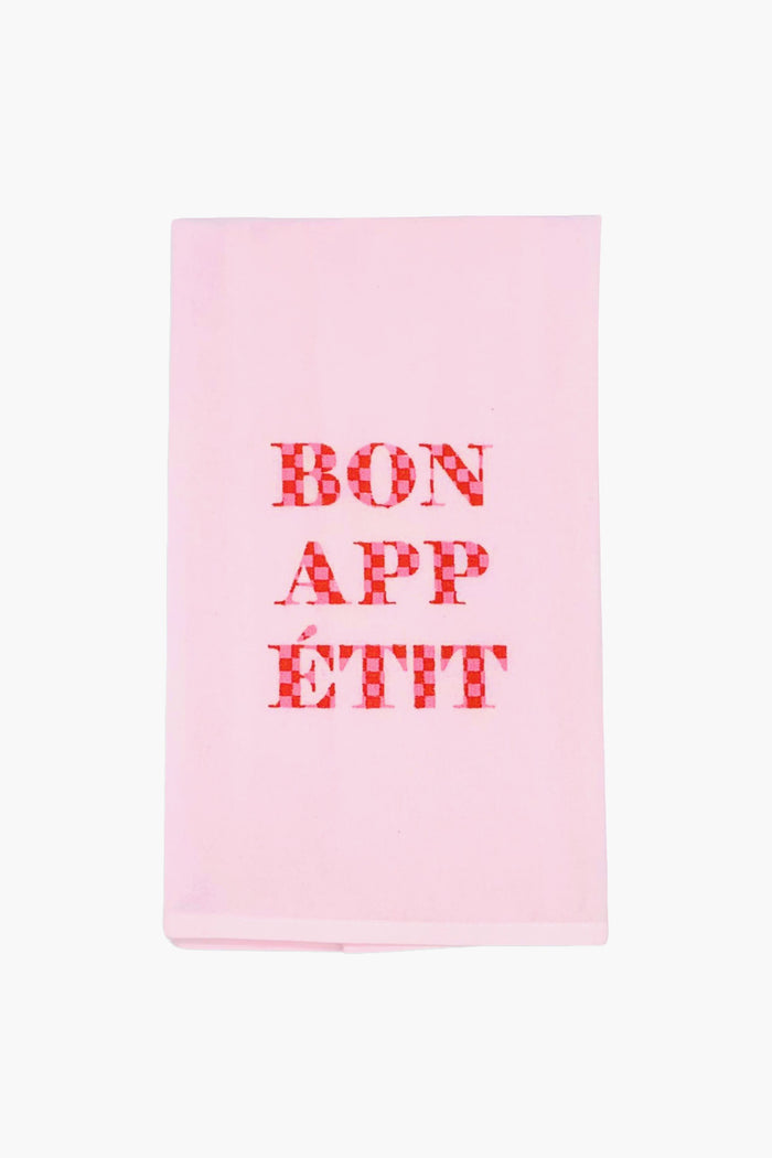 The Lynen Bon Appetit Tea Towel features light pink linen with "BON APPÉTIT" in red checkered letters at the center, adding charm to any kitchen.