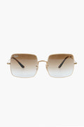 Ray-Ban rectangular sunglasses with gold frames, brown gradient lenses, and the Ray-Ban logo on the left lens, displayed in a sleek showcase.