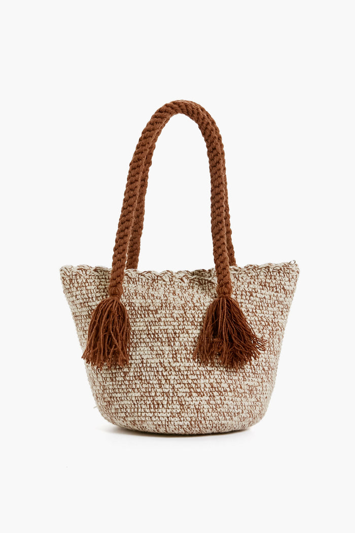The Marina Orth Foundation mini tote bag features two thick braided handles, tassels, and a beige-brown color scheme. Expertly handwoven in San Jacinto, Colombia, it blends tradition with modern style.