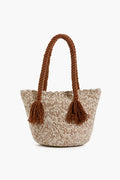 The Marina Orth Foundation mini tote bag features two thick braided handles, tassels, and a beige-brown color scheme. Expertly handwoven in San Jacinto, Colombia, it blends tradition with modern style.