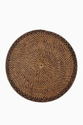 Caton's Wharf round woven rattan placemat features a brown and tan pattern, crafted in natural tones.