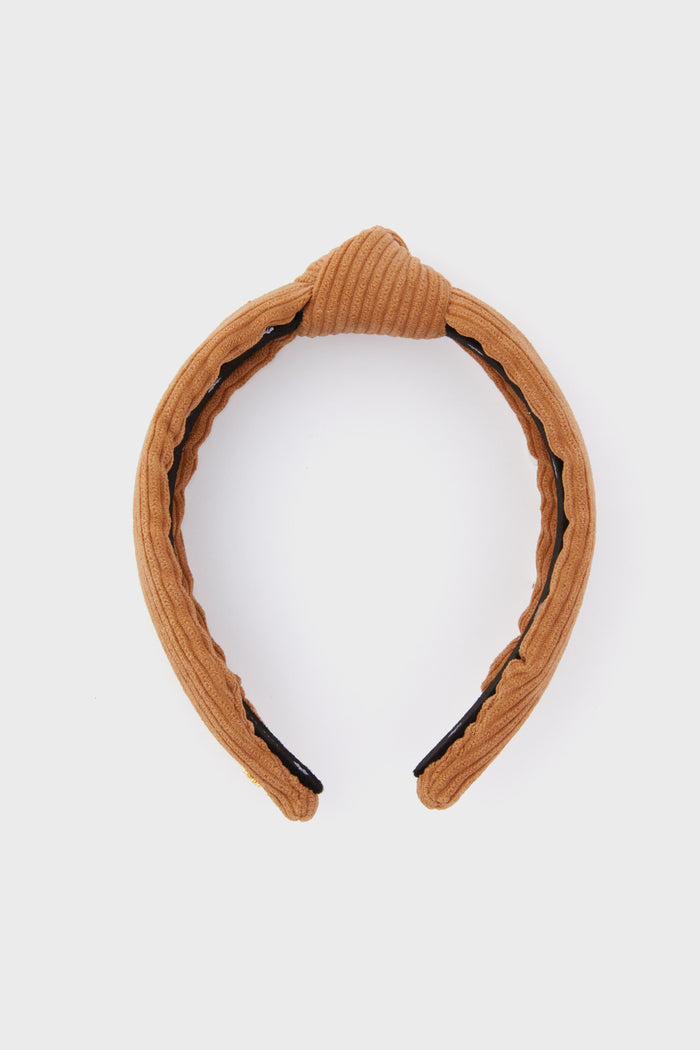 A tan ribbed corduroy headband by Lele Sadoughi, featuring a classic central knot design.