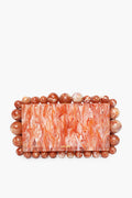 Cult Gaia rectangular marbled orange box clutch featuring acrylic pearl beads along the edges.