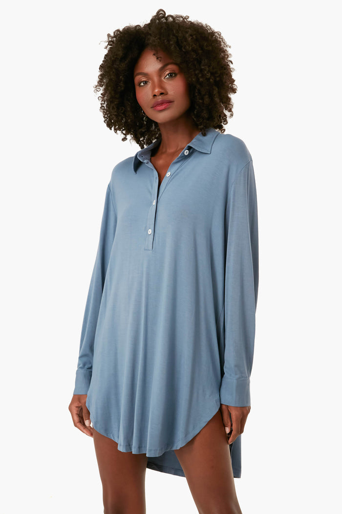 A person wears an Eberjey loose-fitting, long-sleeve, light blue boyfriend sleepshirt with a collared neckline and front buttons.