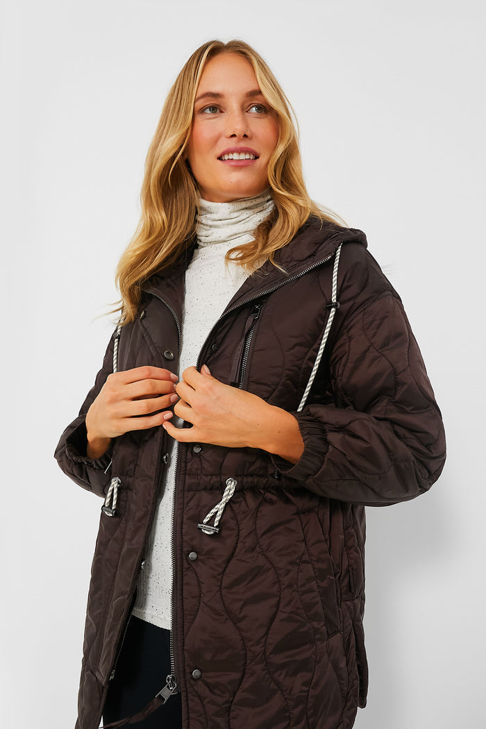 A woman in a black quilted Varley jacket, the perfect cold-weather staple.