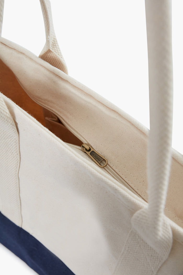Colorblock Utility Tote featuring natural canvas, navy base, and rope handles, with top zip closure and interior pocket, blending classic style with eco-friendly, high-end craftsmanship.