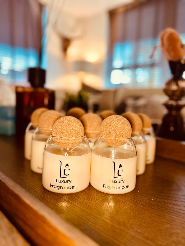 Group of Scented candles with cork ball lid on a wooden table.