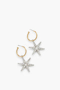 A pair of gold hoop earrings with silver, rhinestone-encrusted star pendants—luxury accessories handmade in New York by Jennifer Behr.