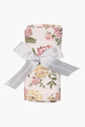 An Angel Dear bamboo baby blanket swaddle, featuring a floral pattern and tied with a gray "angel dear" ribbon, is an ideal nursery essential.