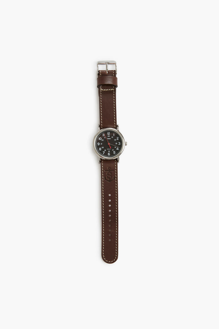 The Sounder Goods wristwatch features a handmade full-grain leather strap, silver buckle, and a black analog face with white numbers and hands.