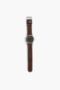 The Sounder Goods wristwatch features a handmade full-grain leather strap, silver buckle, and a black analog face with white numbers and hands.