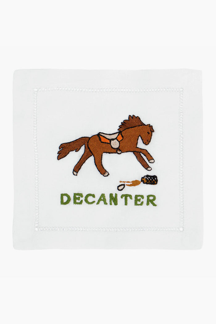 August Morgan’s white linen cocktail napkin showcases an embroidered brown horse, a spilled decanter, and “DECANTER” stitched in green—an elegant addition to your barware collection.