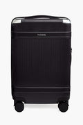 The Paravel black sustainable carry-on features a ribbed hard-shell made from recycled polycarbonate, silver accents, and four wheels. The Paravel logo is displayed near the top center.