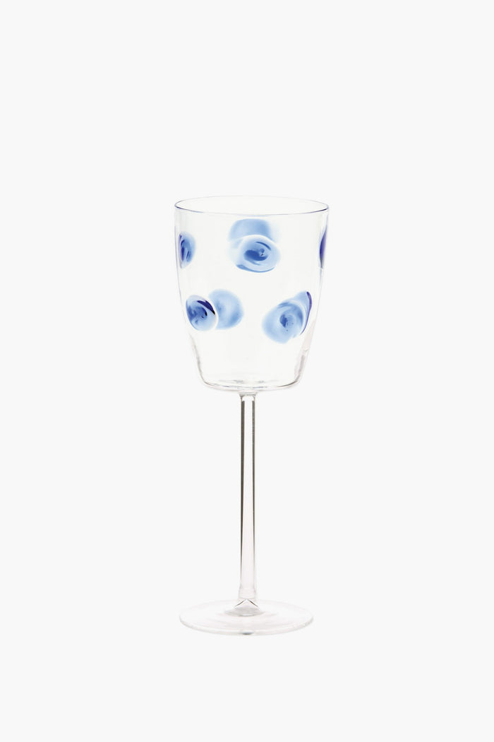 Vietri handmade wine glass featuring blue circular swirl patterns evenly distributed on the bowl, inspired by Italian barware.