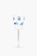 Vietri handmade wine glass featuring blue circular swirl patterns evenly distributed on the bowl, inspired by Italian barware.