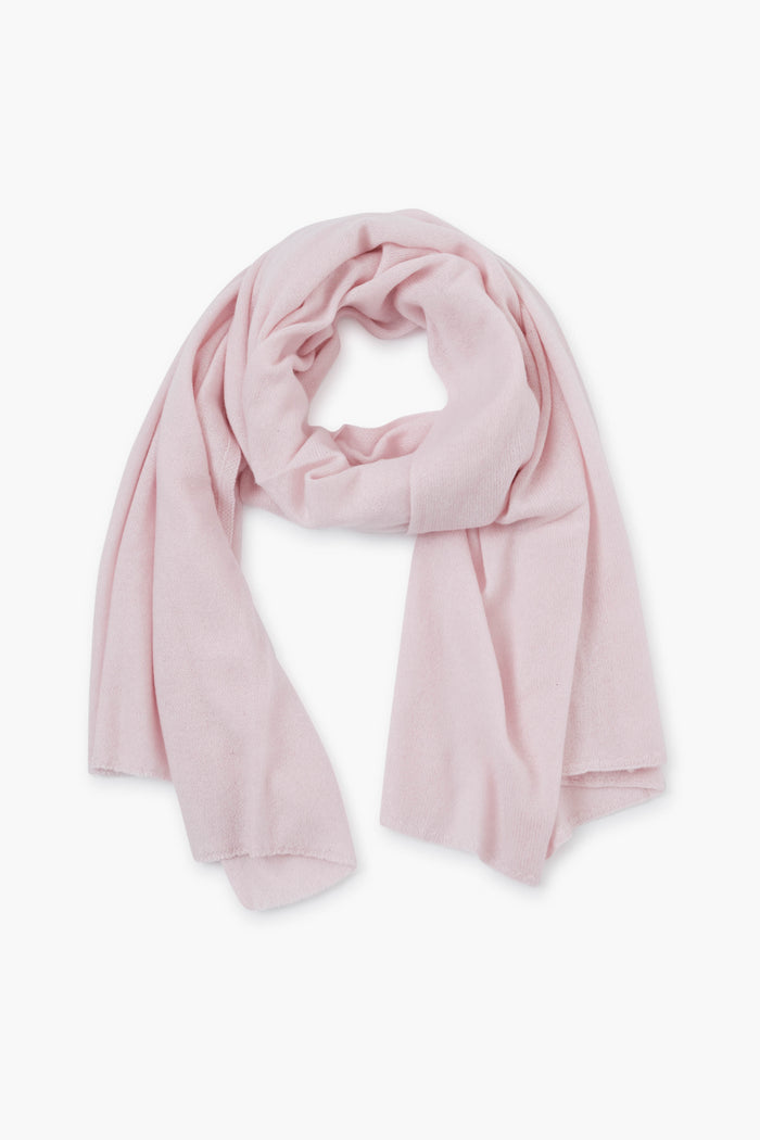 Amicale light pink luxury cashmere scarf crafted from soft fabric, loosely folded and laid flat.