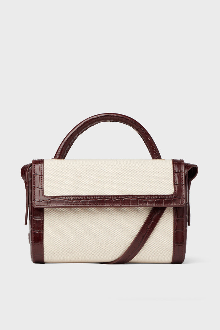 Rectangular Neely & Chloe crossbody with cream canvas, dark brown faux croc accents, top handle, and shoulder strap—a refined luxury piece for handbag lovers.